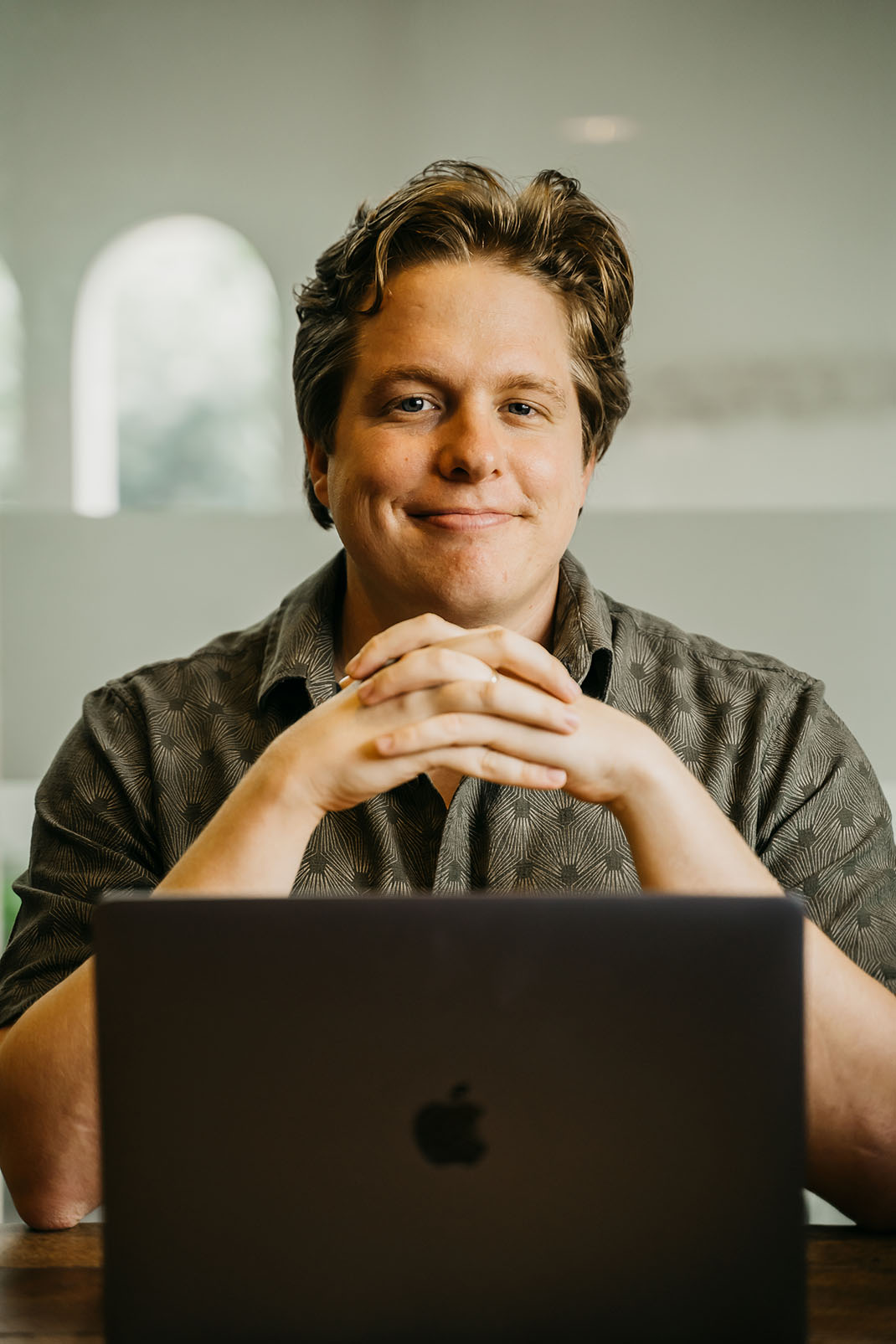 Justin Hardy, marketing strategist, smiling at his laptop